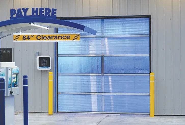 Automatic car wash entrance with a blue-lit Survivor polycarbonate door