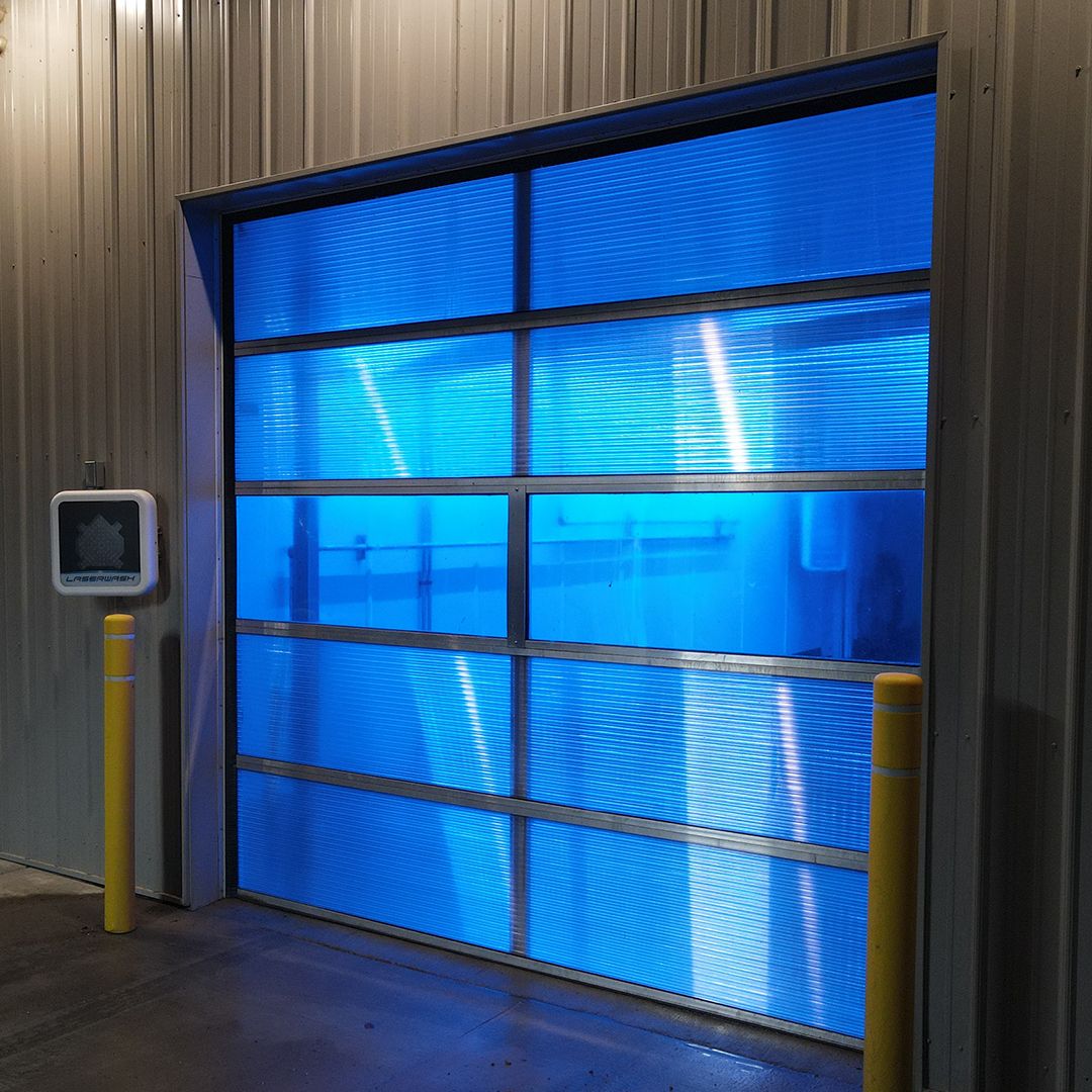 Close exterior view of the illuminated blue Survivor door at Northdale Car Wash