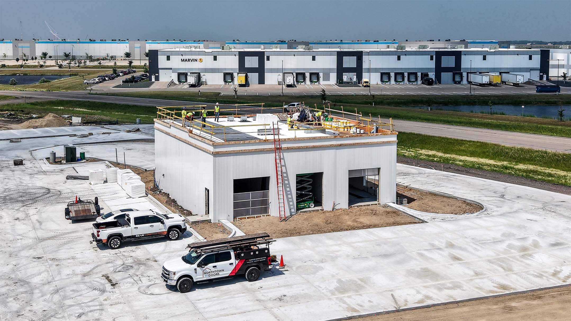 Northdale Oil car wash building under construction in north Fargo with the Marvin facility and Amazon fulfillment center across the road