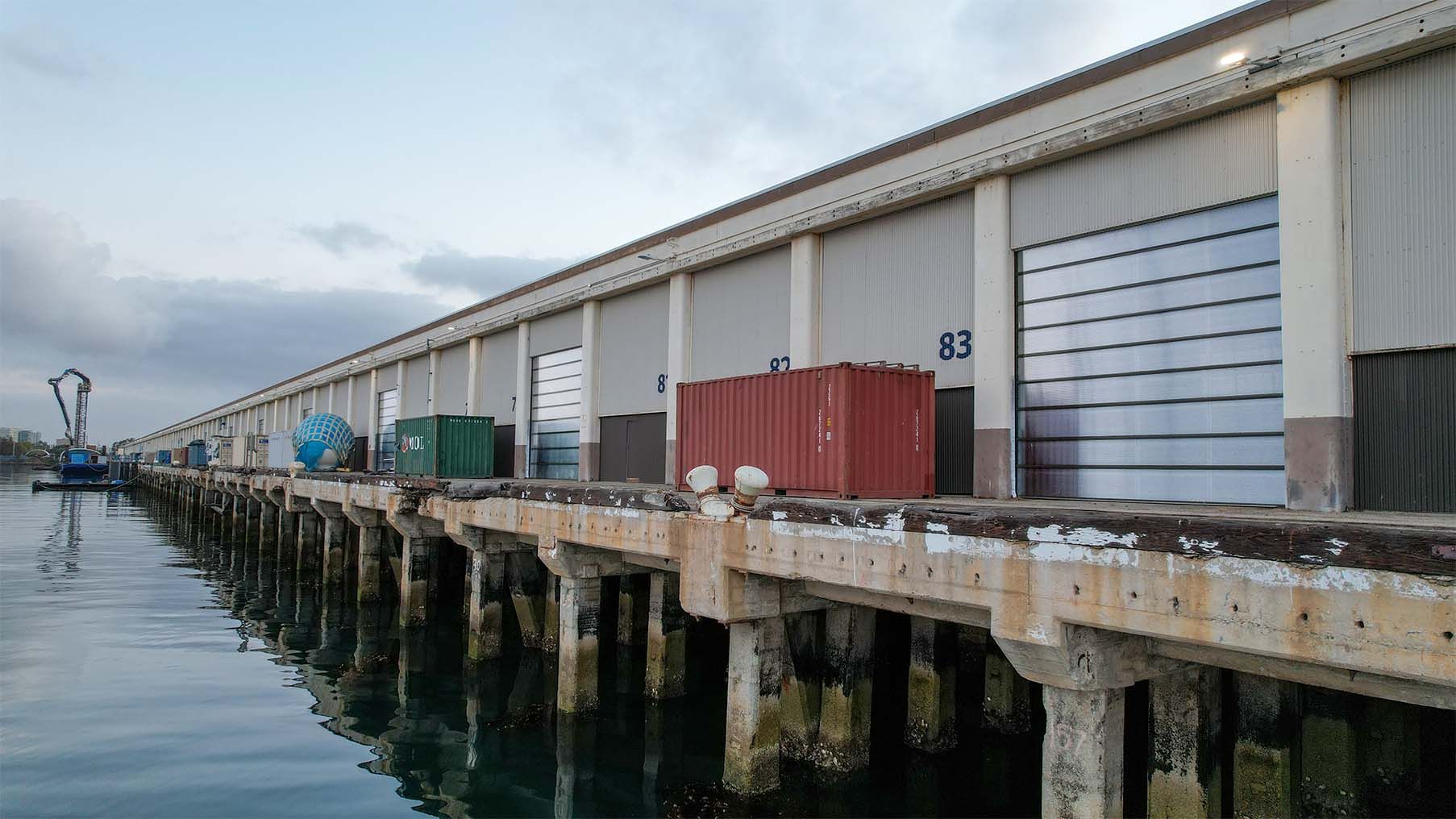 Wharf elevation over the water with translucent Survivor doors closing the numbered berth bays